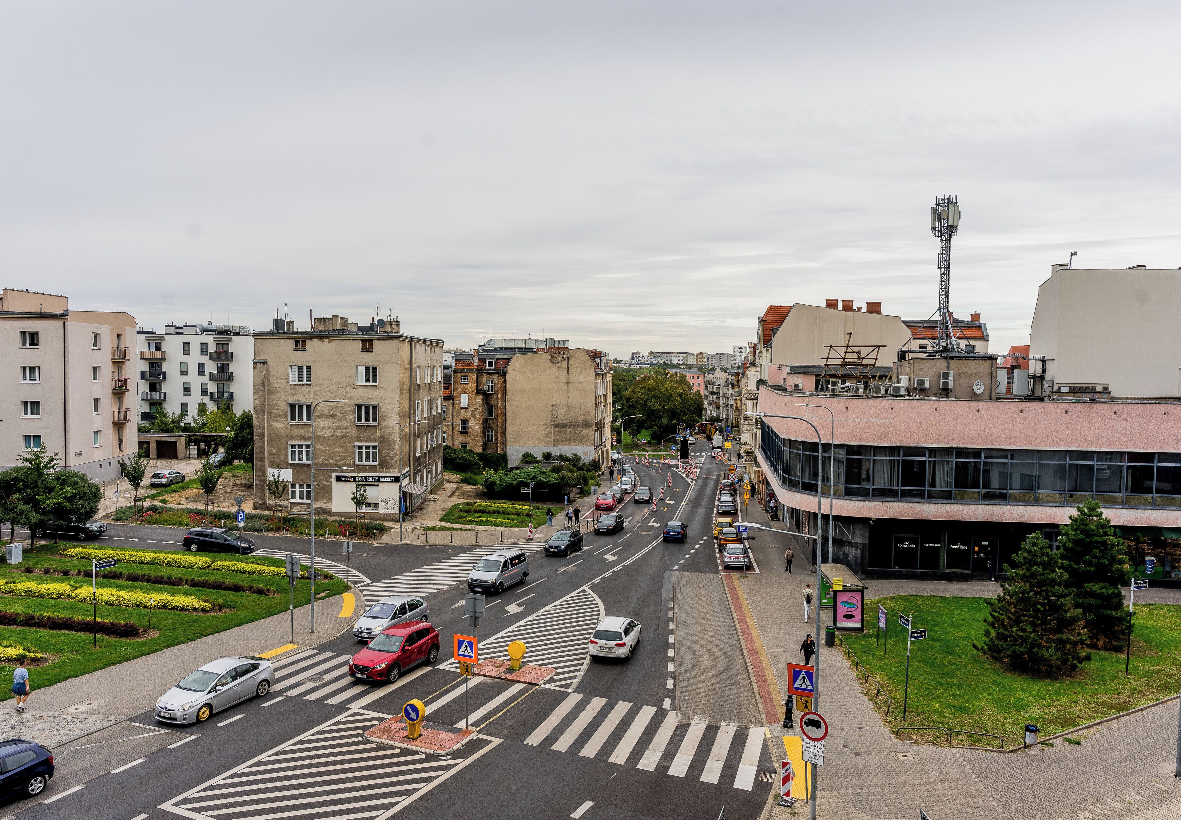 Eine Stadtstraße mit Gebäuden, Autos und Fußgängern.