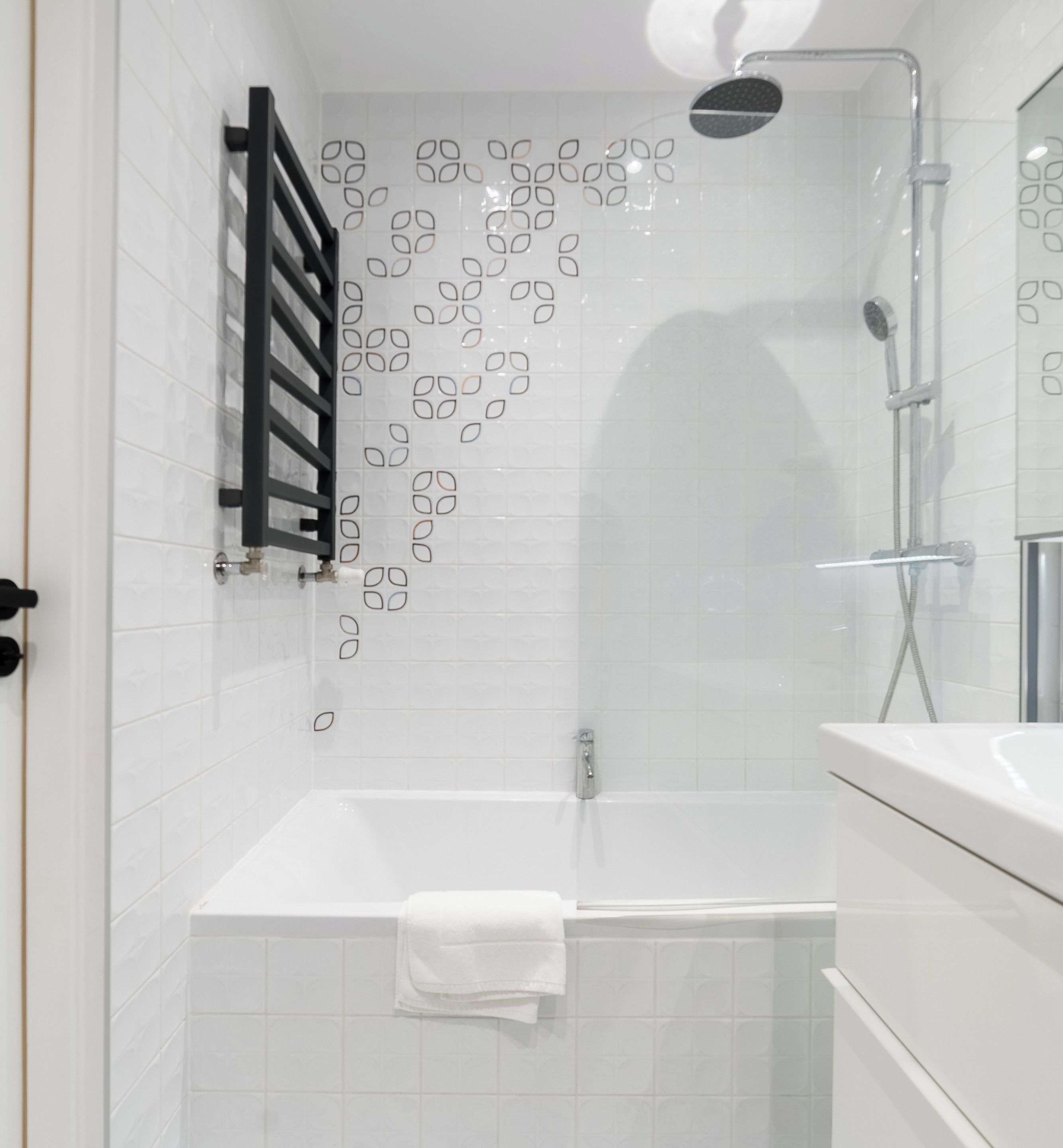 Een badkamer met een douche, een bad en een wastafel.