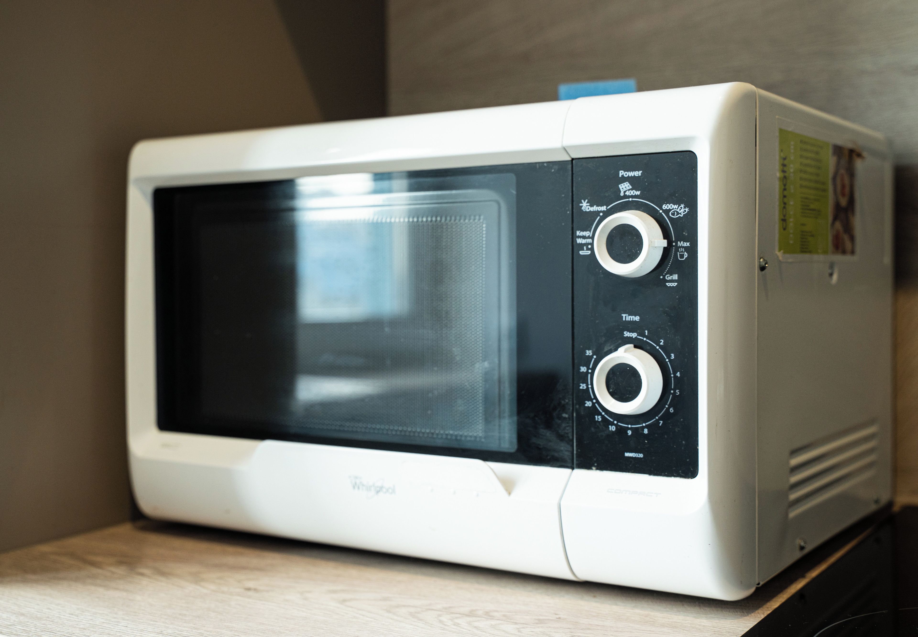 A white microwave oven with two control knobs and a digital display.