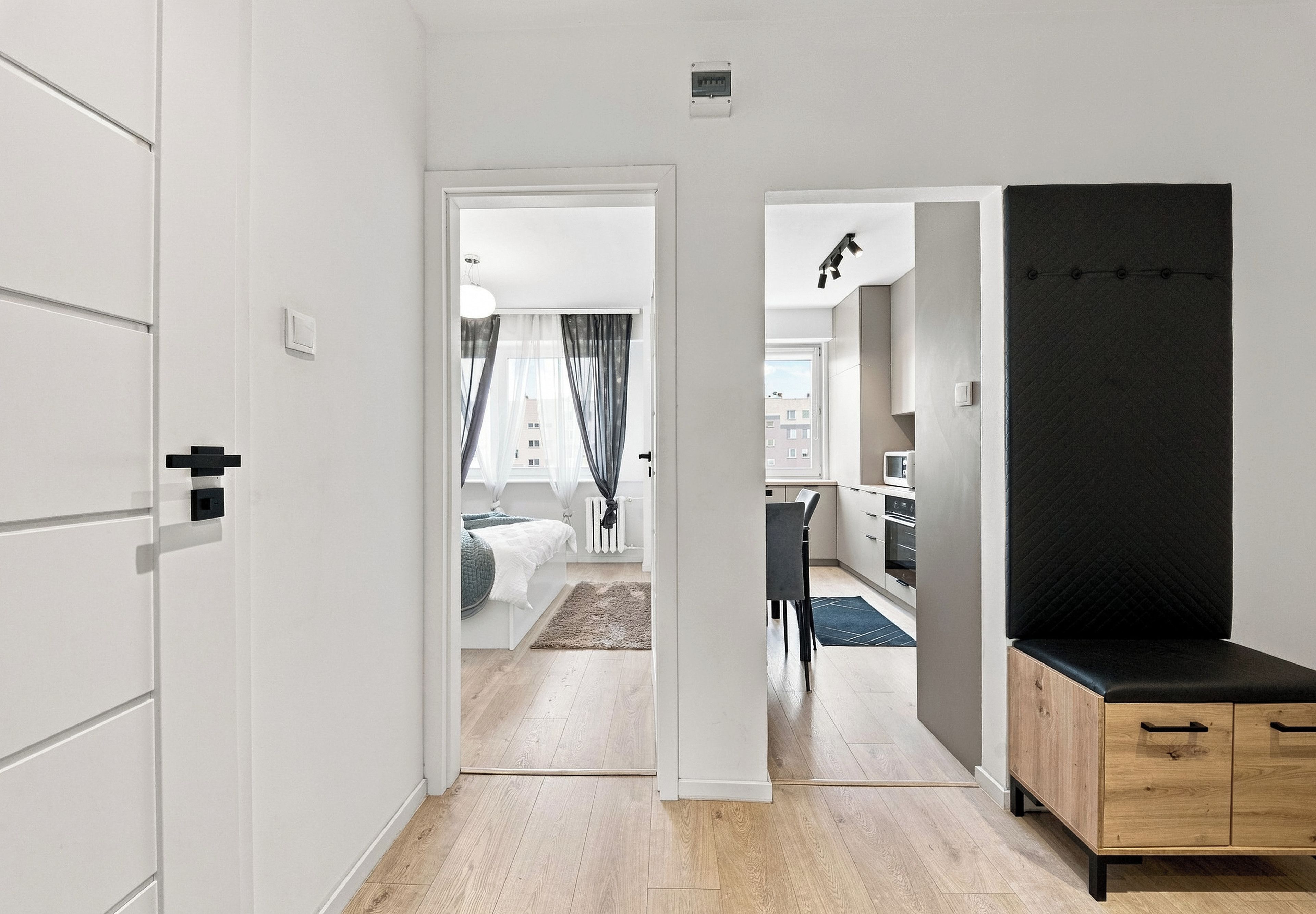Un interior modern amb un passadís que condueix a un dormitori i una zona de cuina.