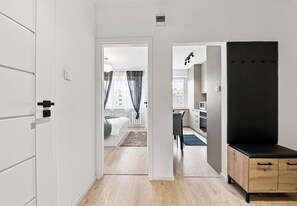 Un intérieur moderne avec un couloir menant à une chambre et à un espace cuisine.