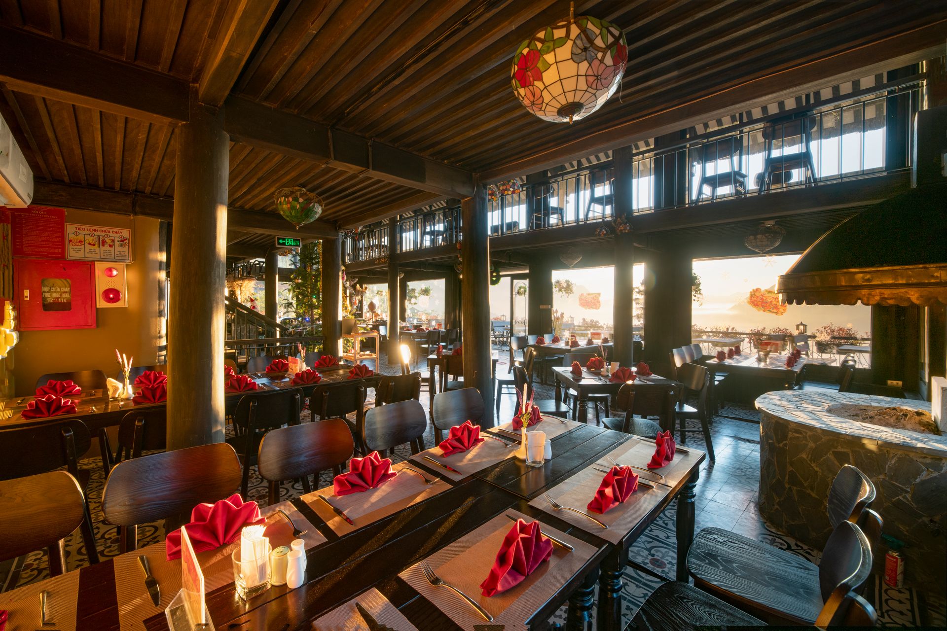 Un restaurante con varias mesas, sillas y una lámpara decorativa en el techo.