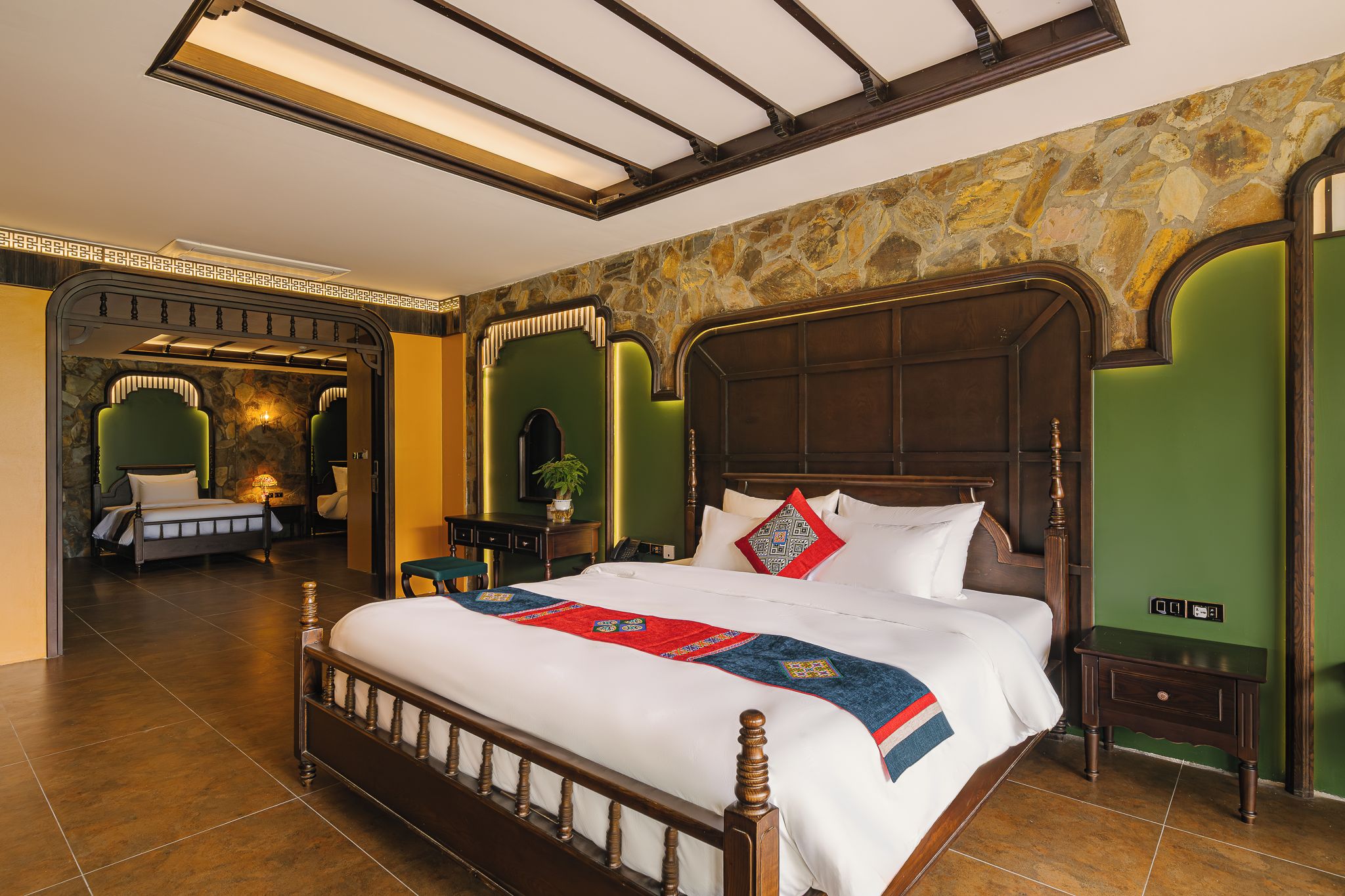 Ein Hotelzimmer mit einem großen Bett, einer Steinwand und einer Wand in Grünton.