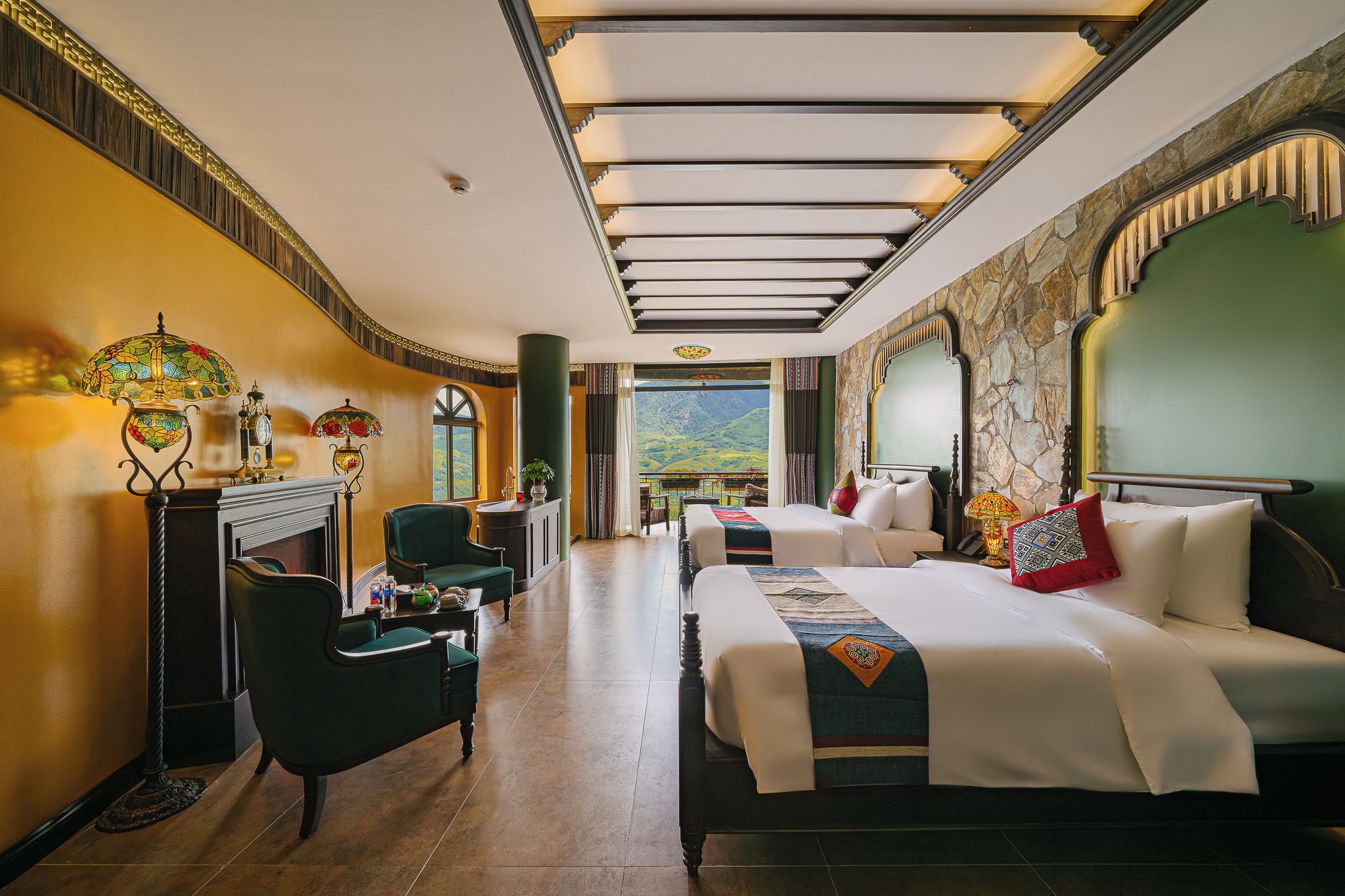 Habitación de hotel con una cama grande, un sofá, un escritorio y vistas a la montaña.