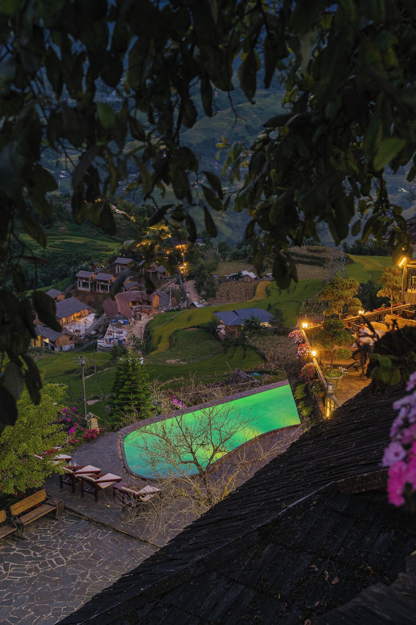 Un paisaje escalonado con casas, piscina y terraza de madera.