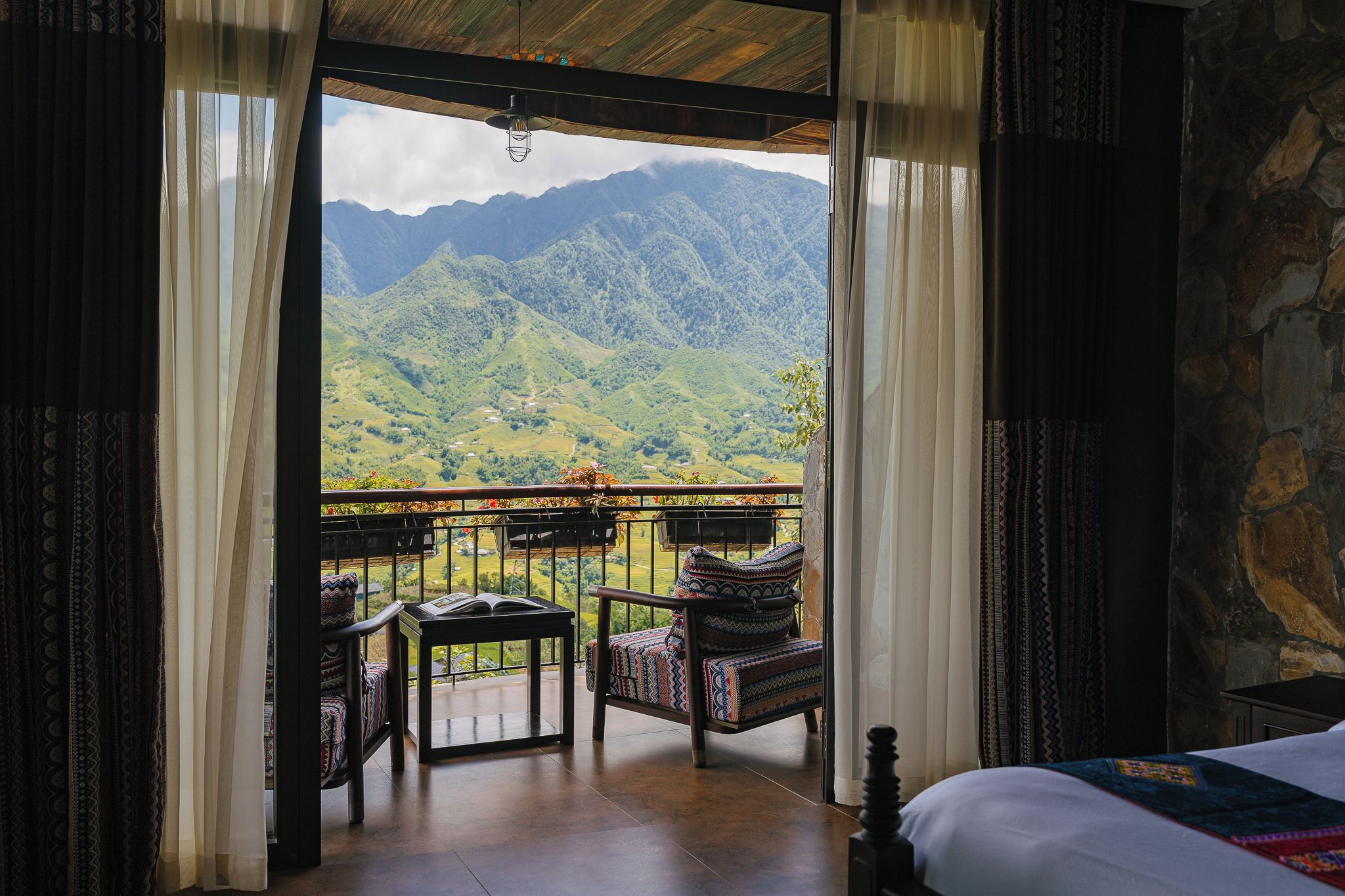 Una habitación con balcón con vistas a un paisaje montañoso.