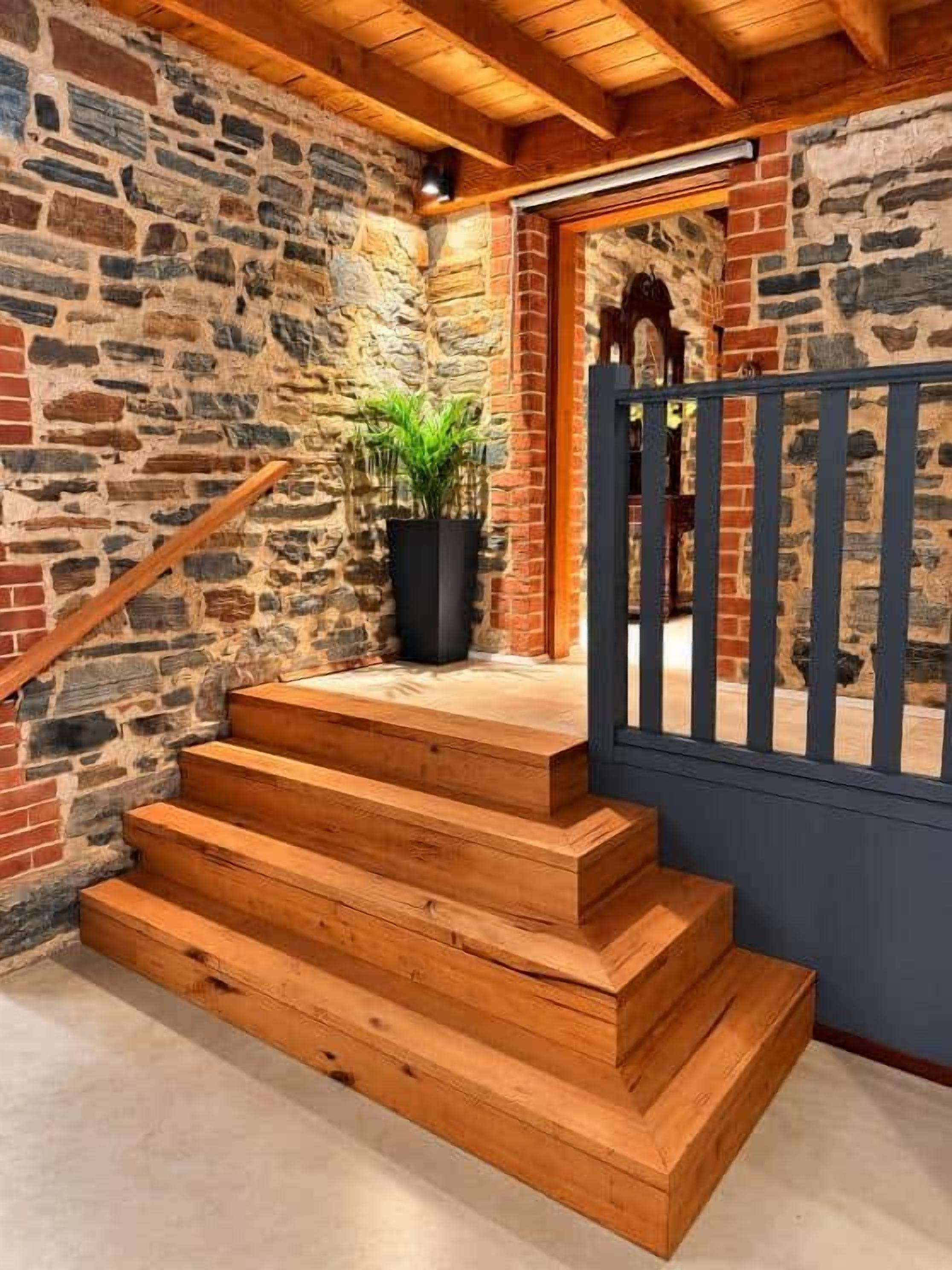 A staircase with wooden steps leading to a door with a blue gate.