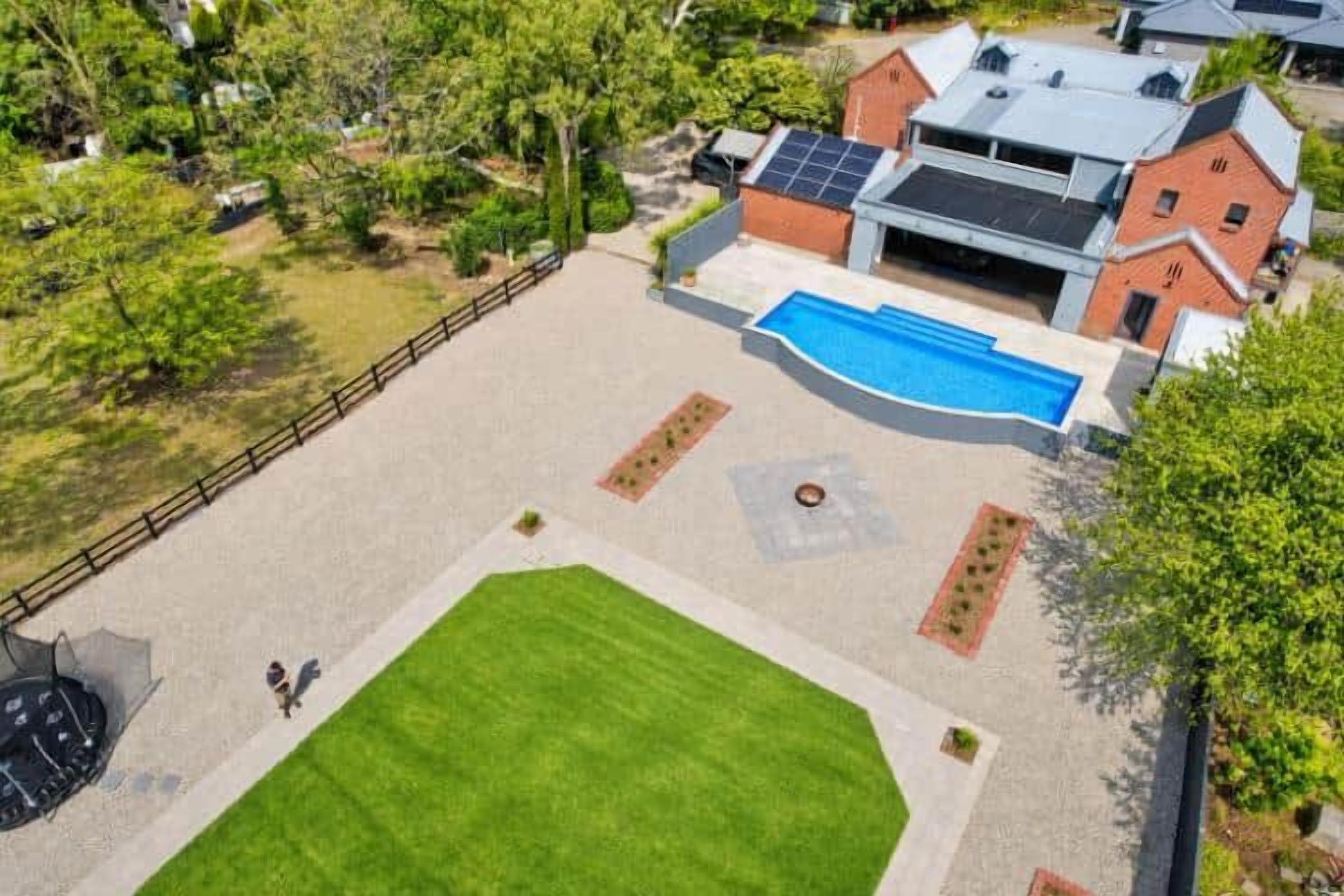 Une propriété résidentielle dotée d’une piscine, d’une cour clôturée et d’un garage.