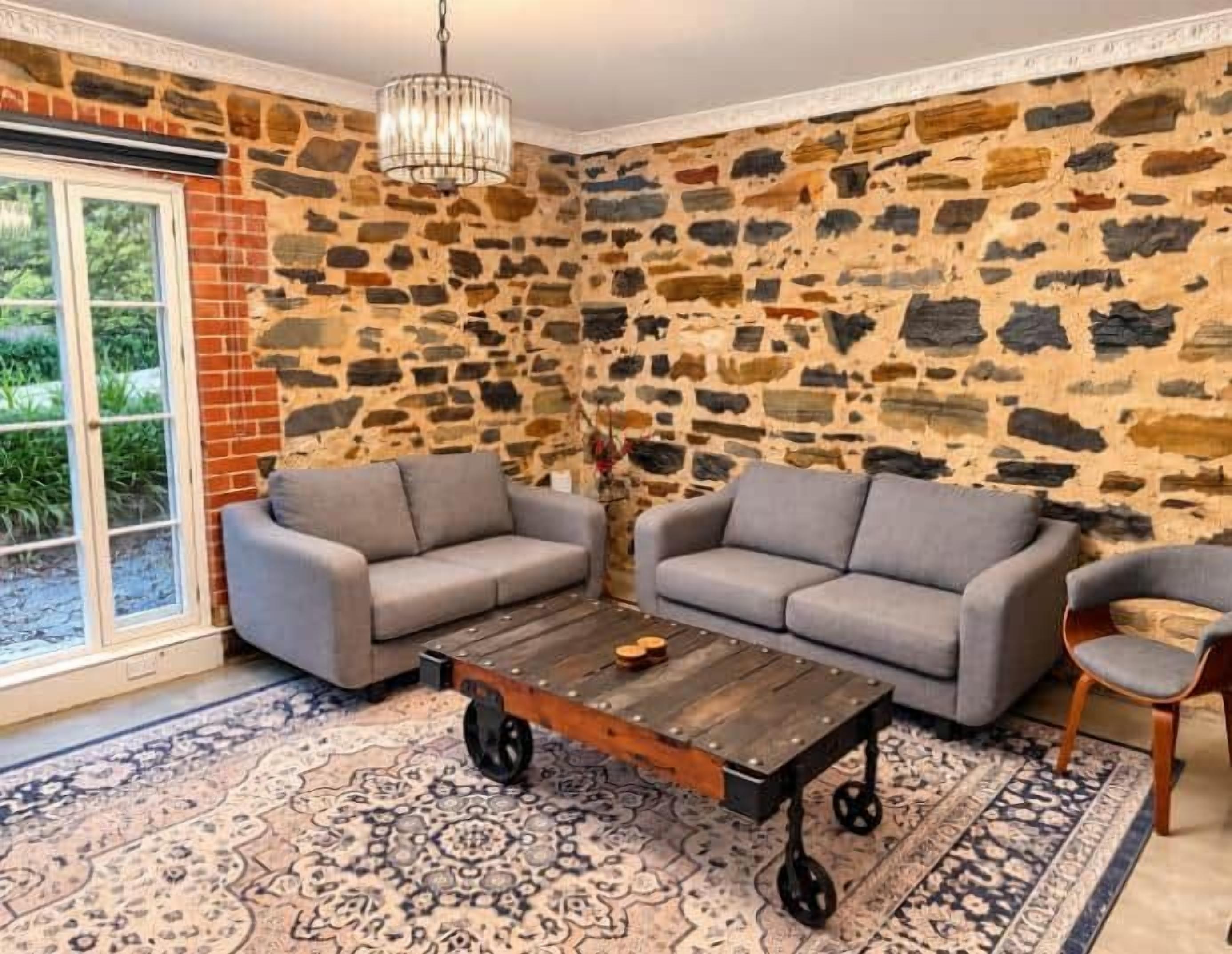 A room with two grey sofas, a wooden coffee table, and a patterned rug.