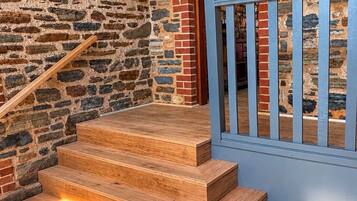 A staircase with wooden steps and a metal railing leading to a doorway.