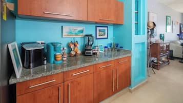 A kitchen with wooden cabinets, a granite countertop, and various kitchen appliances.