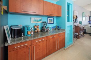 A kitchen with wooden cabinets, a granite countertop, and various kitchen appliances.