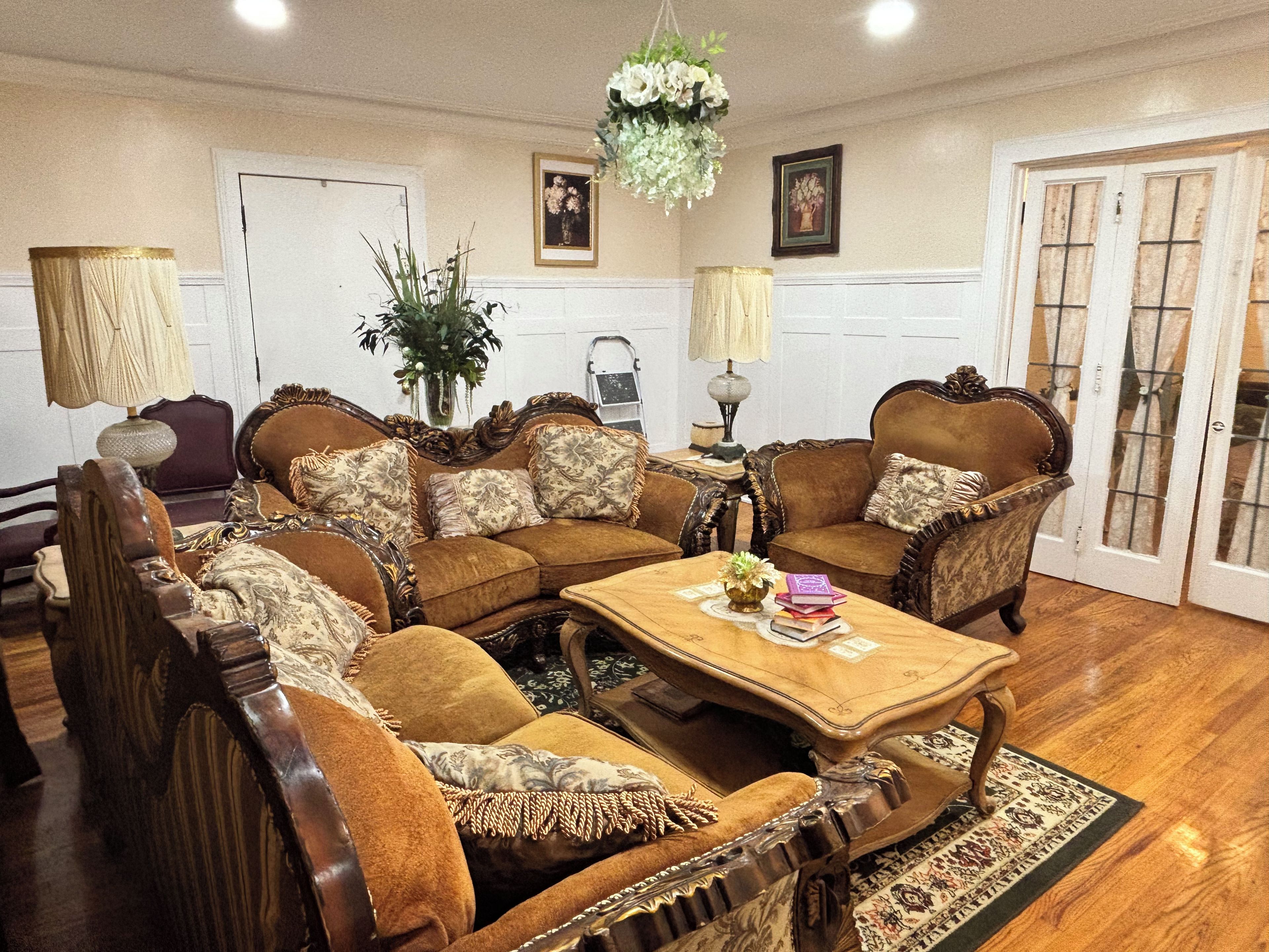 A traditional living room with a sofa set, a coffee table, and a chandelier.