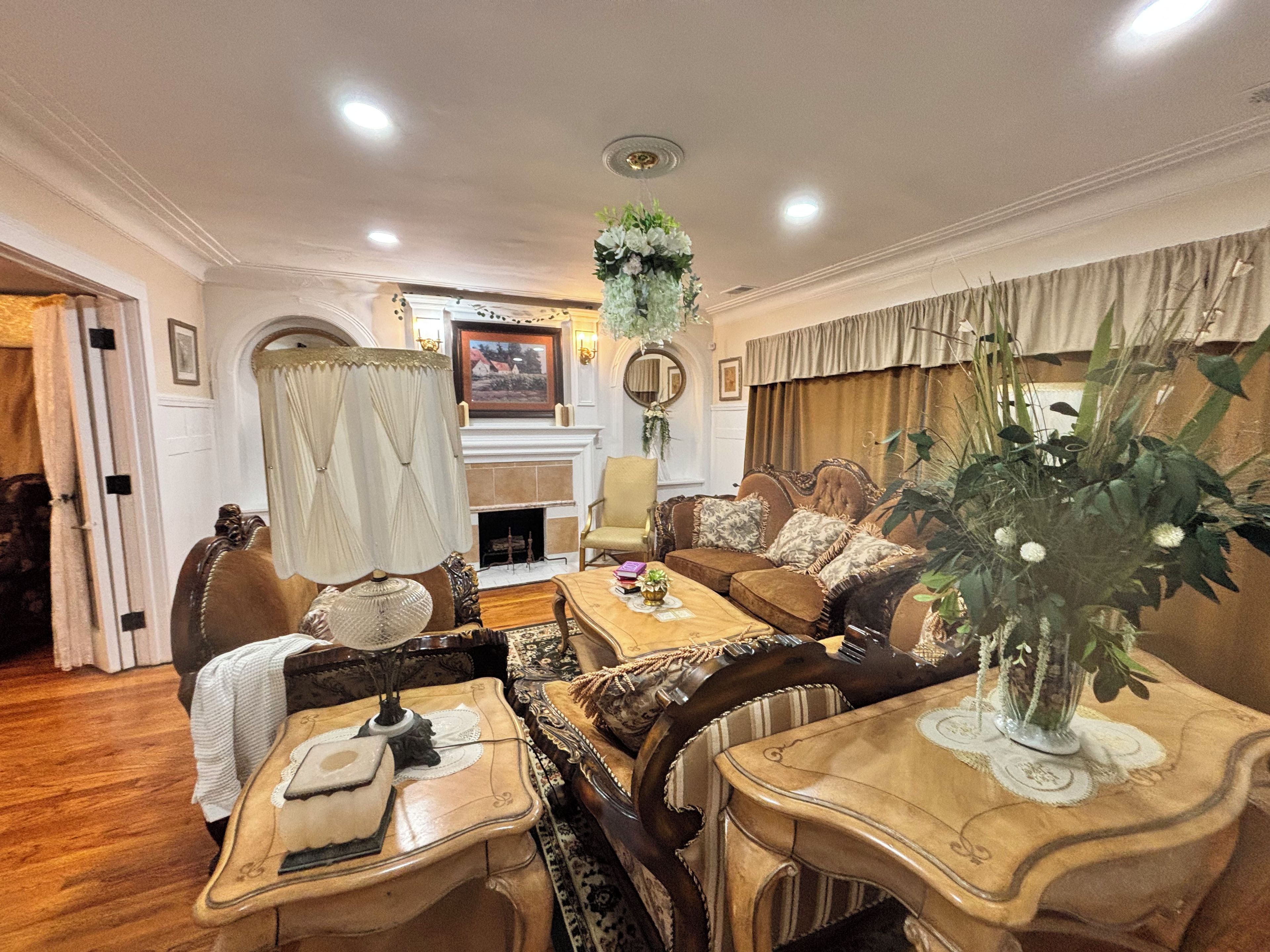 A traditional living room with a fireplace, a dining table, and a sofa set.