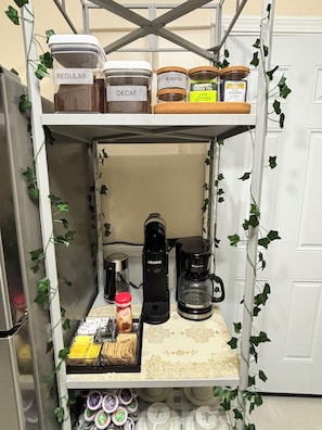 A kitchen shelf with jars labeled 'Regular,' 'Decaf,' 'Black Tea,' 'Green Tea,' and 'Pure Camomile.' - Elegant 1925 Vintage Home (Detroit)