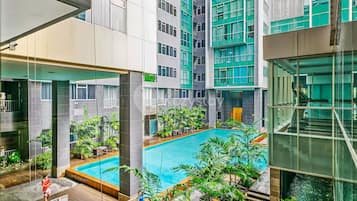 Un edificio moderno con una piscina central rodeada de vegetación.
