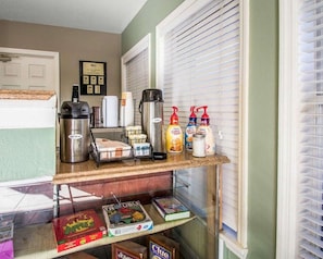 A kitchenette with a coffee maker, a Bunn coffee pot, and coffee creamer bottles.