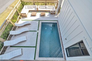 Ein Schwimmbecken mit Liegestühlen und einer Holzterrasse.