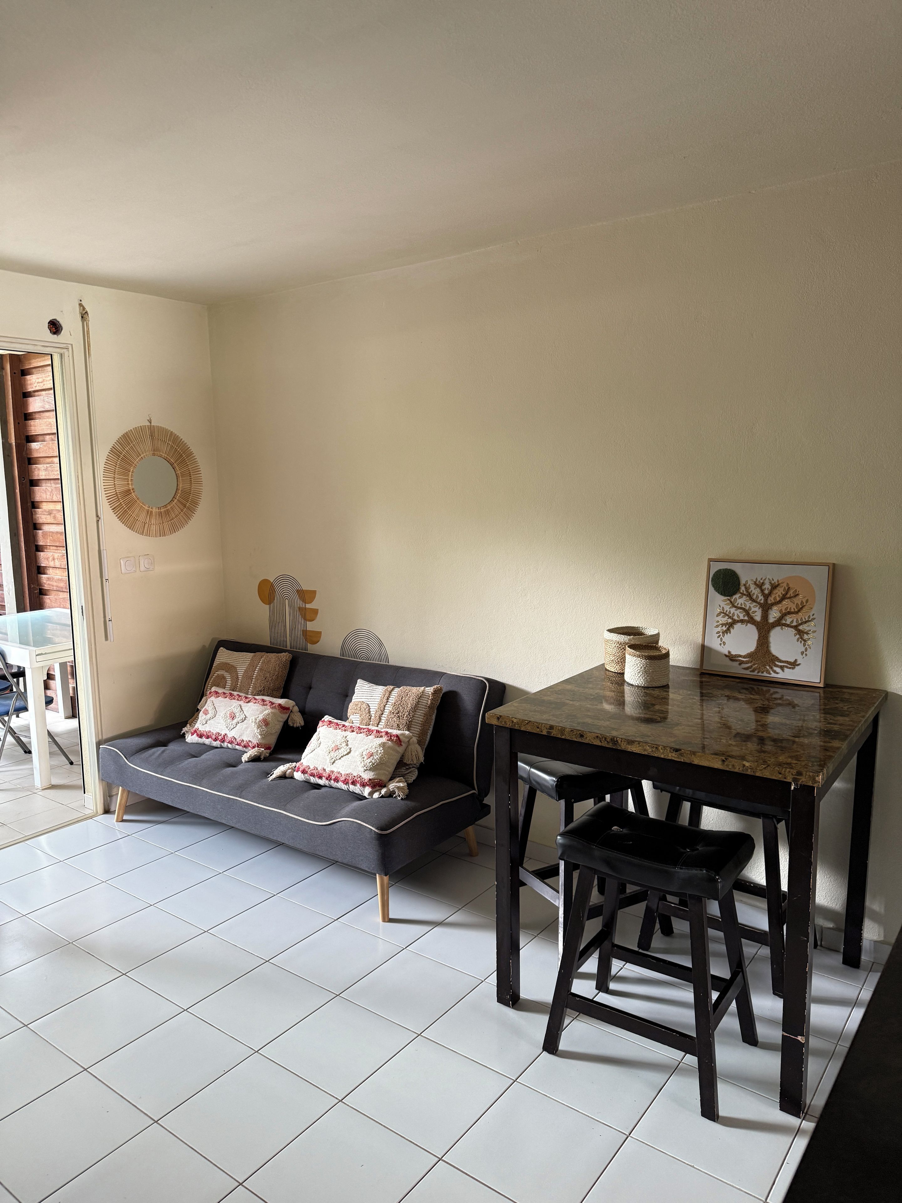 Een woonkamer met een bank, een salontafel en een eettafel.