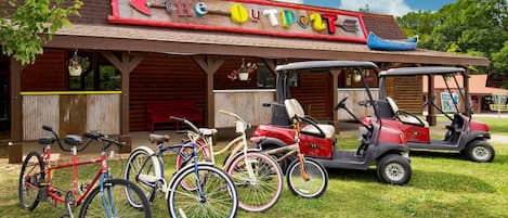 A building with a sign that reads 'The Out Door' and a golf cart parked in front.