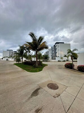 A parking area with palm trees and modern buildings. - Acapulco Diamond House (Acapulco)