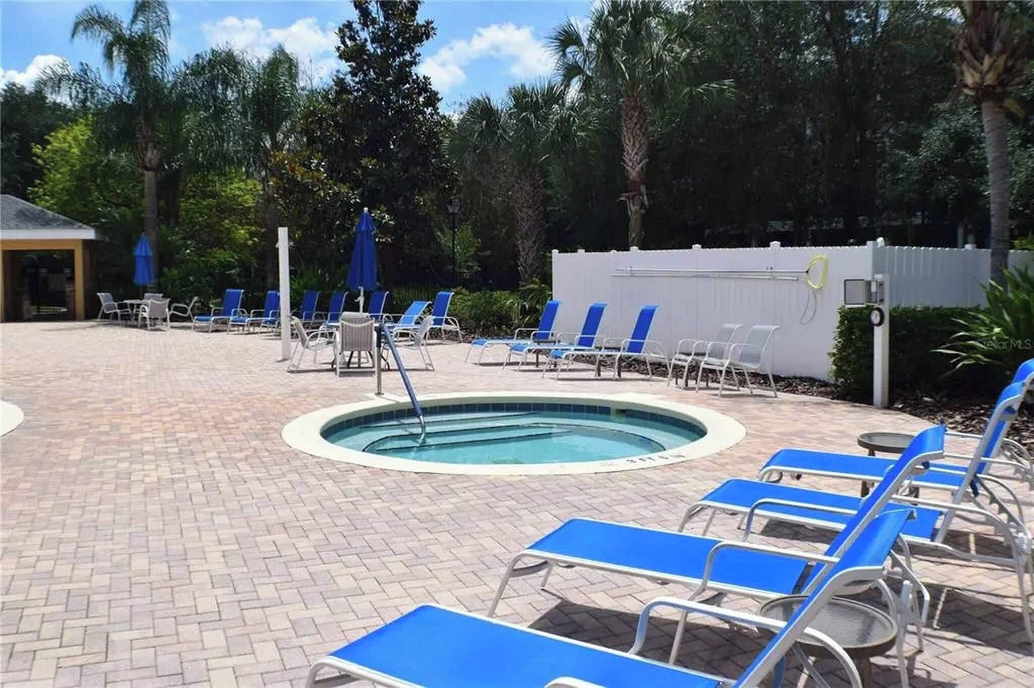 A pool area with lounge chairs and umbrellas.