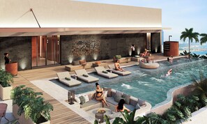 A modern outdoor pool area with lounge chairs, a fire pit, and a city view. - Garrya Danang (Ngu Hanh Son)