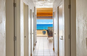 A corridor leading to a balcony with a view of the ocean. - Top Floor Oceanfront 2BR on Po'olenalena Beach (Kihei)