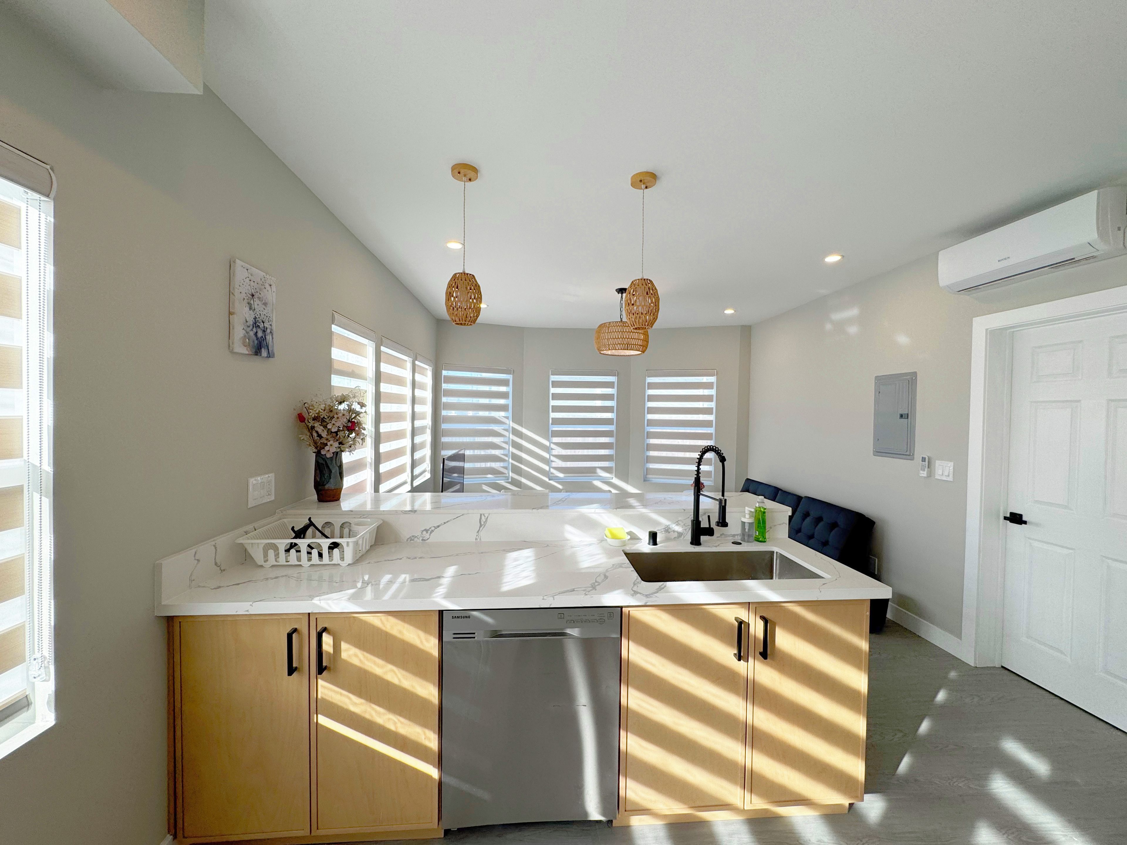 A modern kitchen with a central island, built-in appliances, and a dining area with a bench.