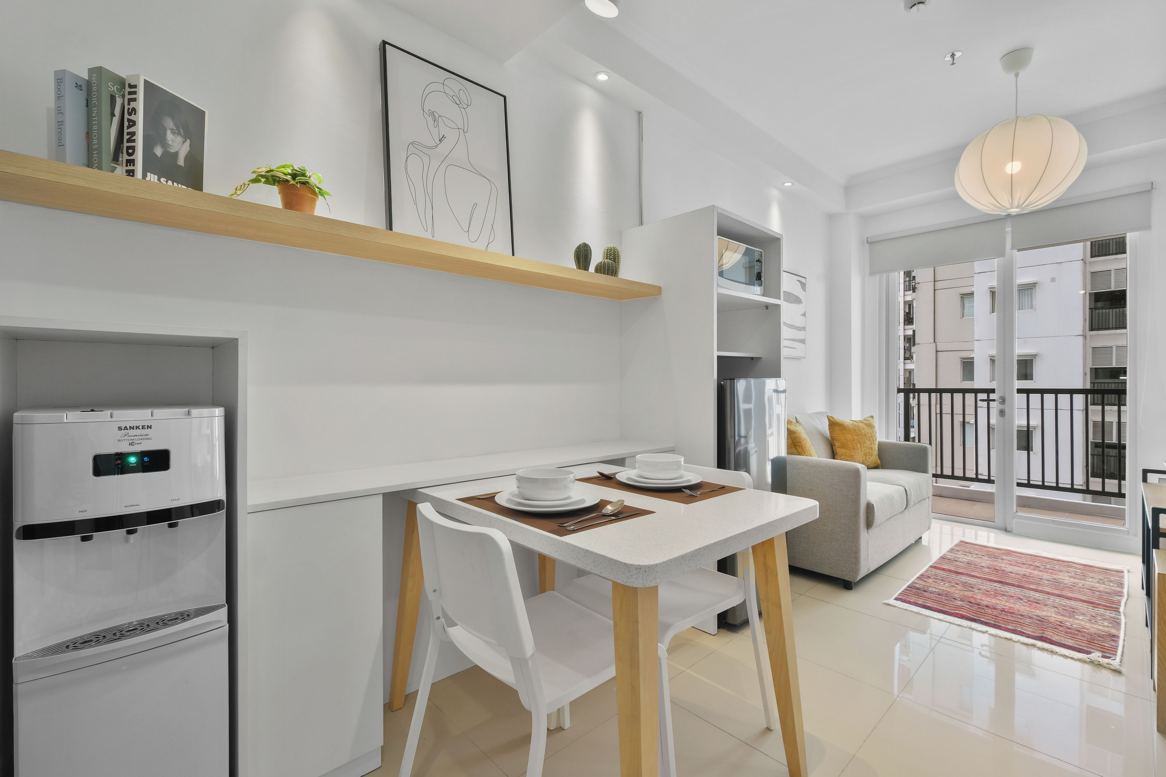 A modern kitchen with a built-in refrigerator, a dining table with chairs, and a small island with a sink.