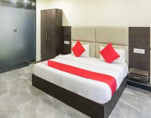Ein Hotelzimmer mit einem Bett, einem Kleiderschrank und einem Nachttisch.