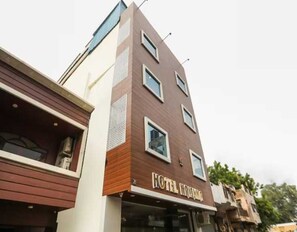 Ein modernes Hotelgebäude mit einer glatten Fassade, zahlreichen Fenstern und einem Schild, das es als Hotel kennzeichnet.