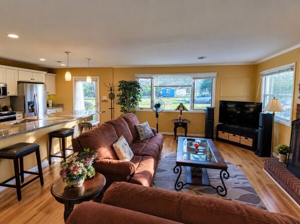 A living room with a brown sofa, a coffee table, and a TV.