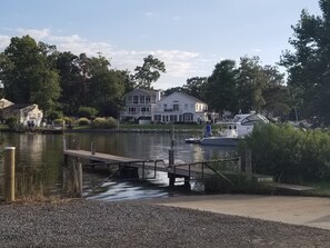 A lakeside property with a dock, a house with a balcony, and a boat.