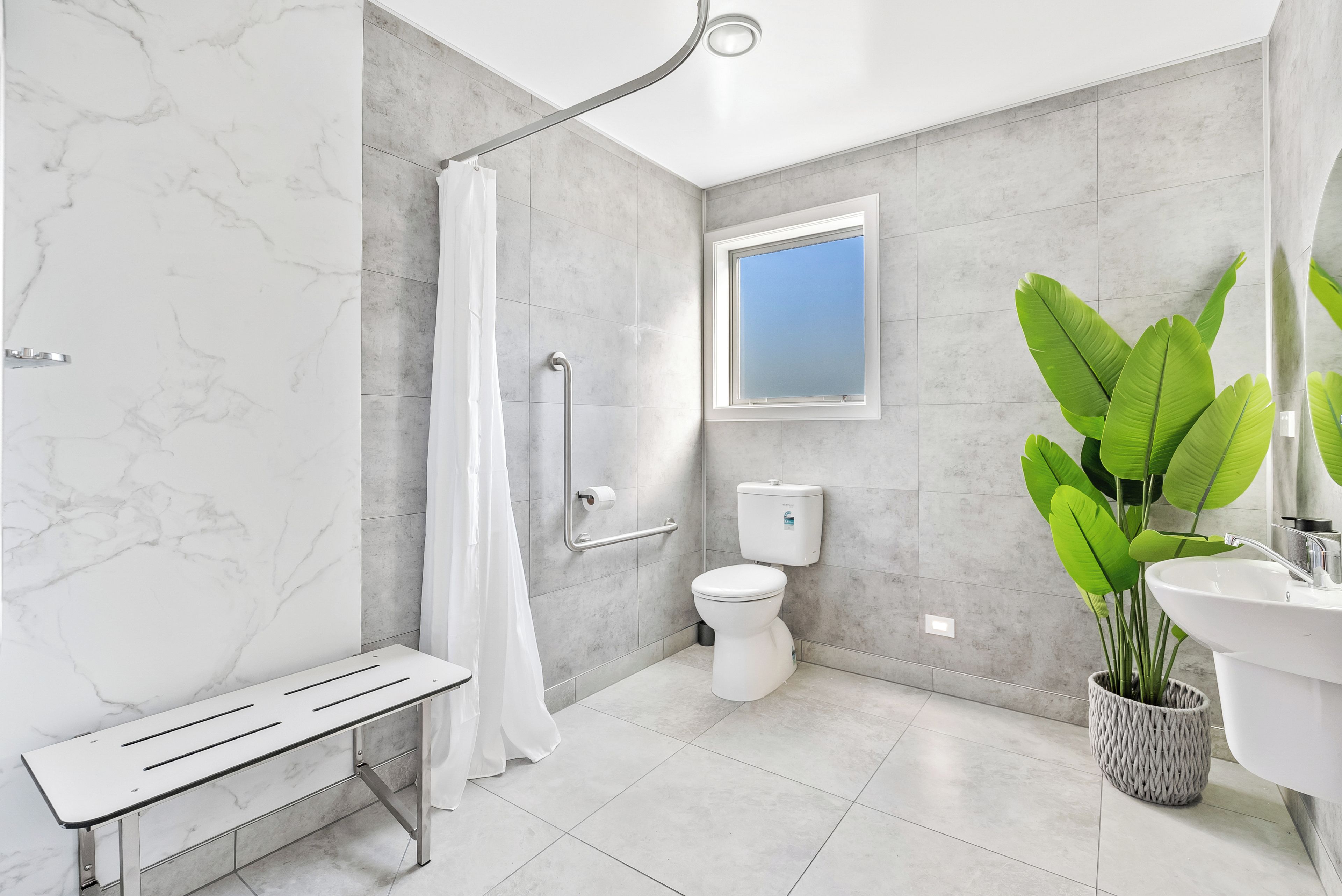 Un baño moderno con ducha, inodoro y lavamanos.
