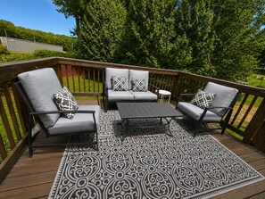 A deck with outdoor furniture, including two chairs and a small table. - Enchanted Forest | Hot Tub | Mins to ATL (Decatur)