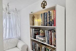 A white bookshelf with books, a decorative globe, and a chandelier. - Romantic Fairytale |10 min to Downtown (East Point)