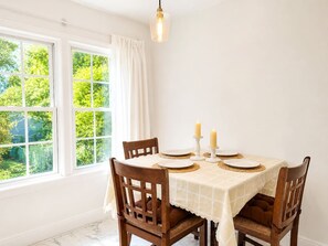 A dining room with a table set for four, featuring a white tablecloth, wooden chairs, and candles. - Romantic Fairytale |10 min to Downtown (East Point)