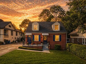 A two-story house with a front porch, a brick facade, and a clear sky. - Romantic Fairytale |10 min to Downtown (East Point)