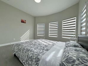 A bedroom with a bed, a desk, and a window with blinds. - 5704- Cozy 2B1B Private Unit near FWY 580/24 & UCB (Oakland)
