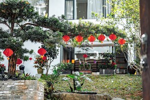A garden with a tree, red lanterns, and a stone wall. - HUIYUAN Wushan (Guangzhou)