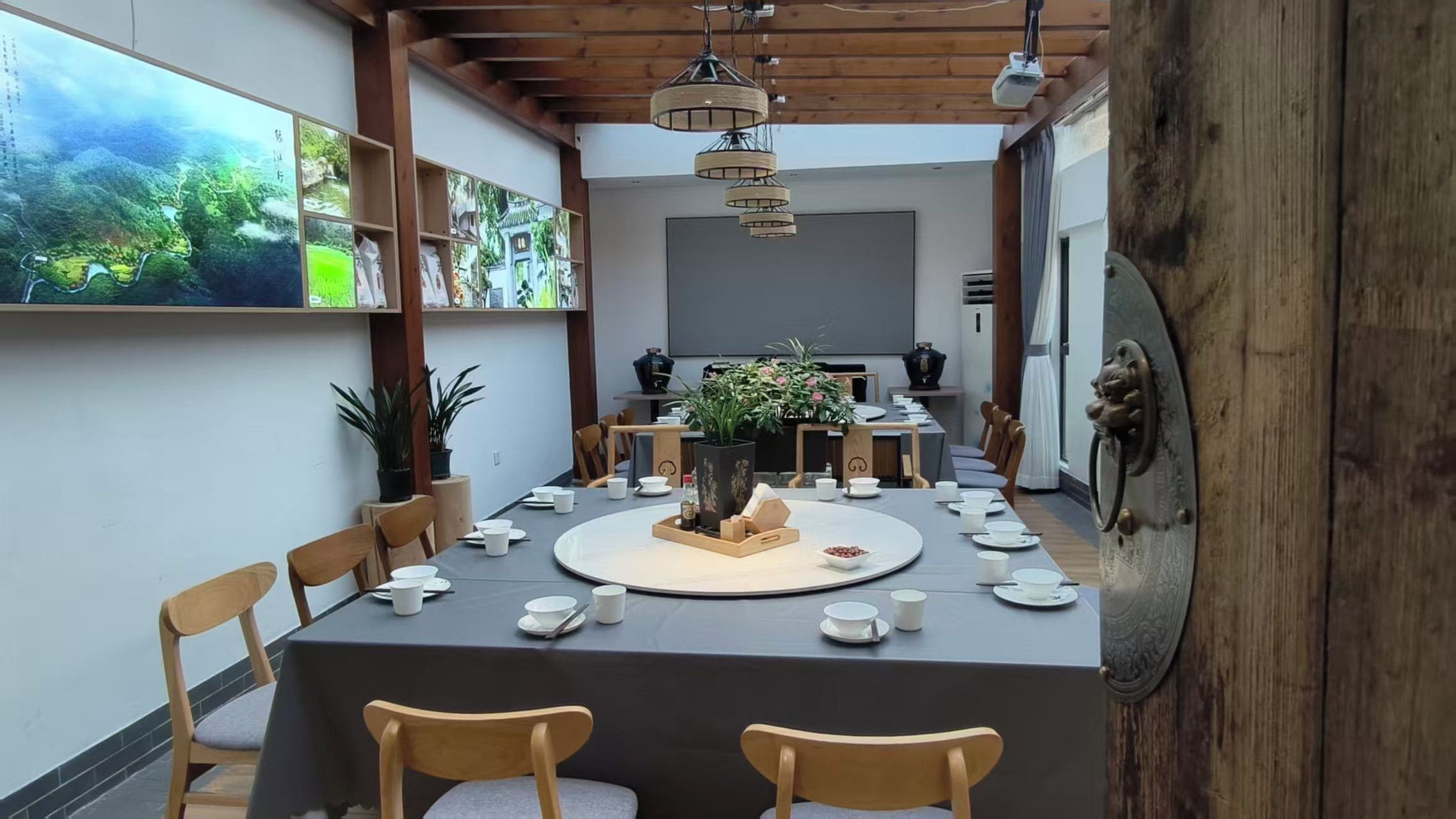 A dining area with a round table set for a meal, surrounded by wooden chairs.