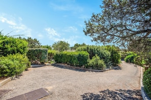 A gravel driveway leading to a building with a metal door labeled 'STELLA.' - Casa Molara, Punta Molara, Italy (Punta Molara)