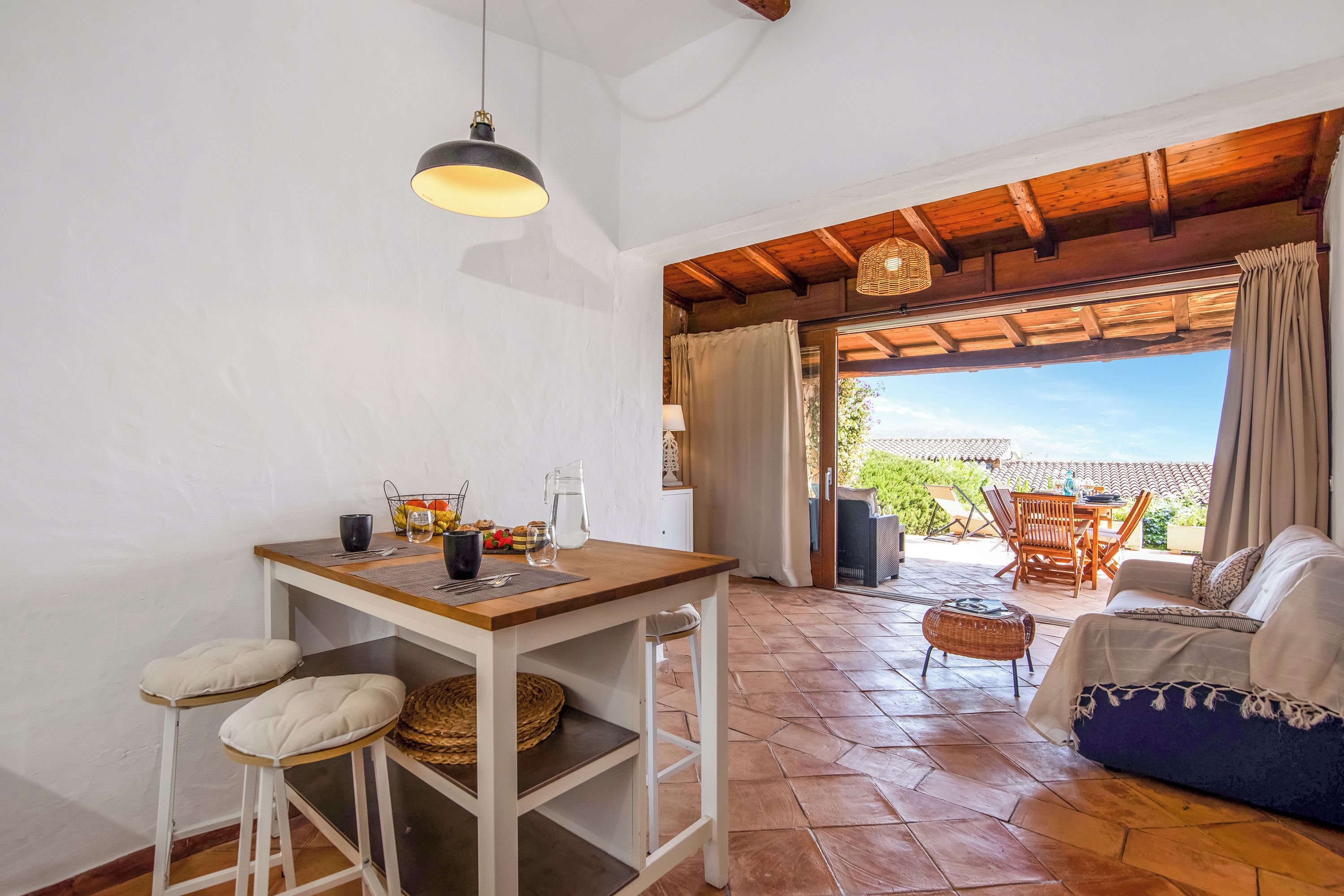 Un interior acogedor con zona de comedor, un sofá y vistas a un patio exterior.