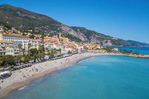 A coastal town with a beach, buildings, and a mountain in the background. - Horizon azur, Menton, France (Menton)