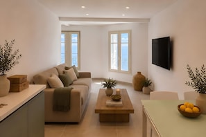 A modern living room with a sofa, coffee table, and a flat-screen TV. - Horizon azur, Menton, France (Menton)