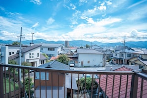 A residential area with houses, a clear sky, and distant mountains.