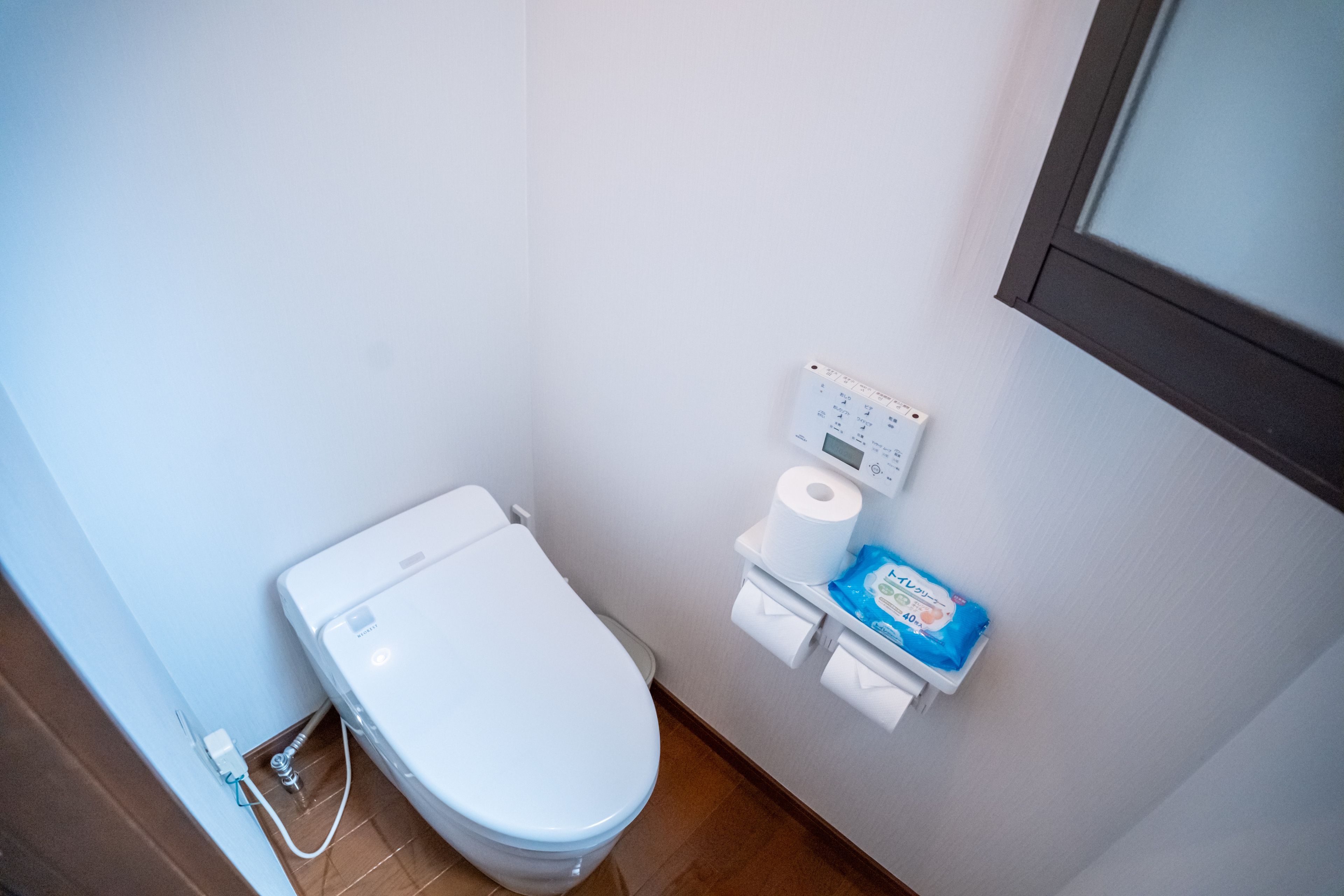Ein kleines, modernes Badezimmer mit Toilette, Toilettenpapierhalter und Bidet.