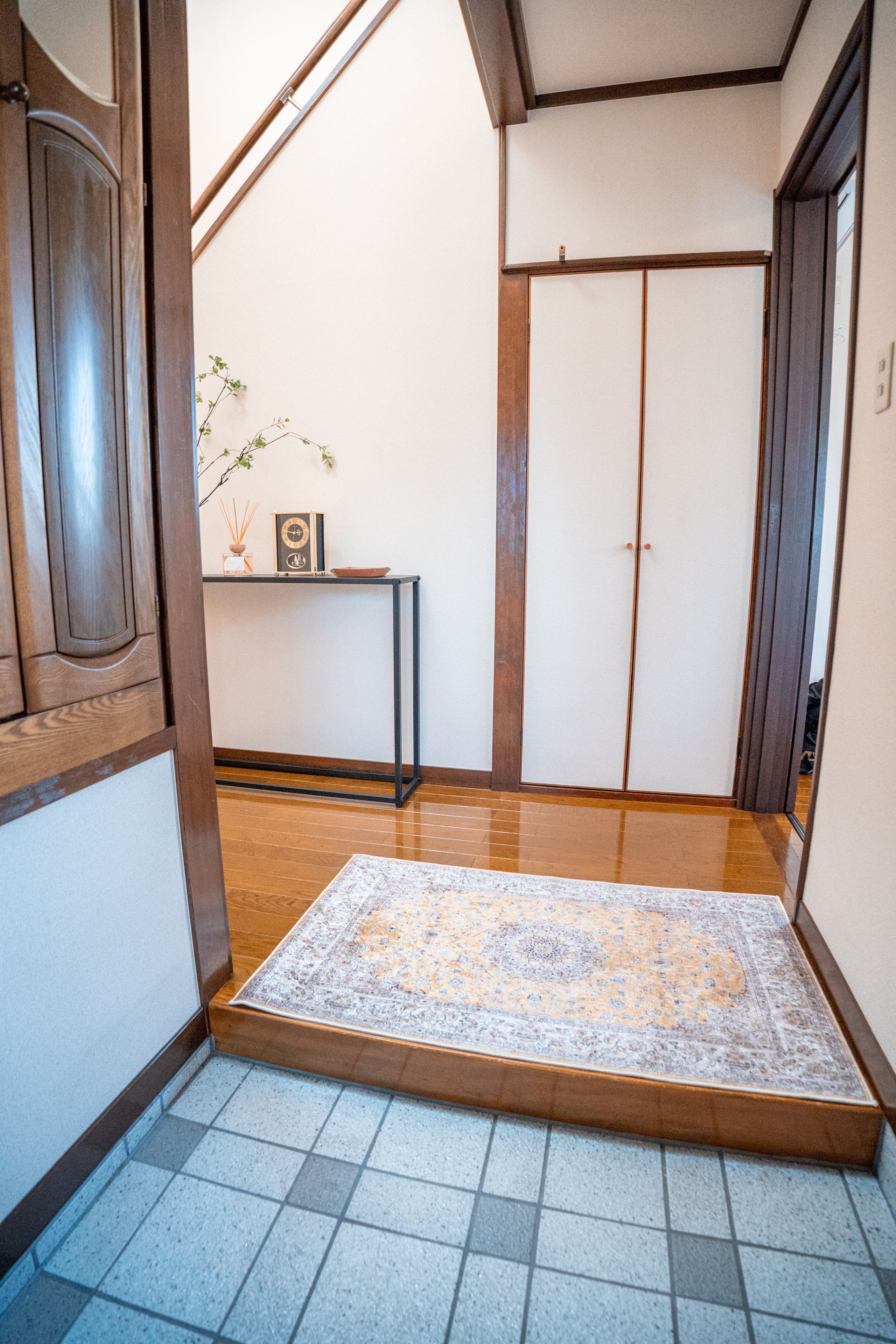 Et traditionelt japansk interiør med tatamimåtter, en shoji skærmdør og et lille bord med et ur og røgelse.