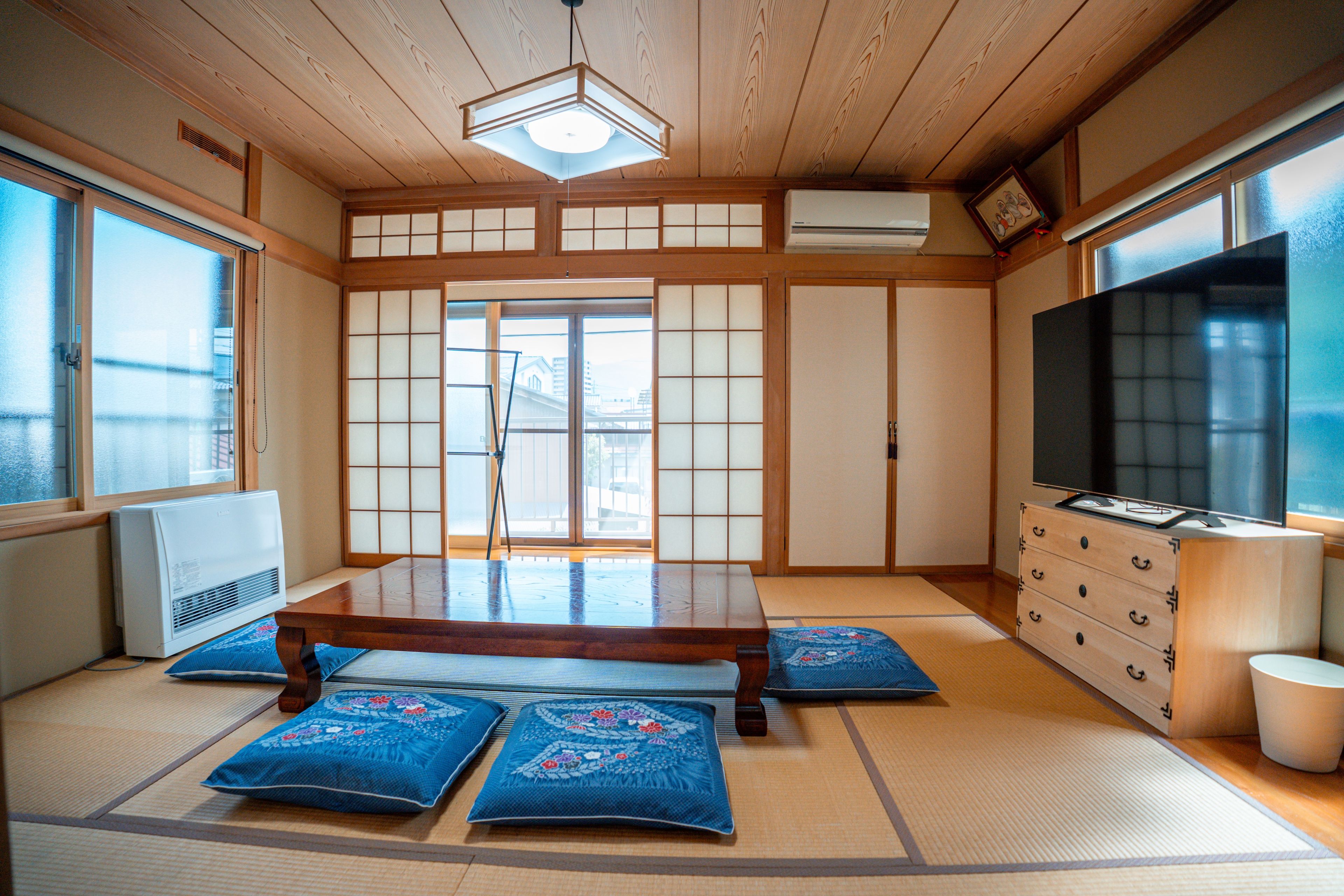 Ein traditioneller japanischer Raum mit Tatami-Böden, einem niedrigen Tisch und Schiebetüren.